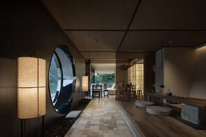 A modern interior with a central walkway, a large round mirror, and a seating area with a bar. - ZHU85 (Lishui)