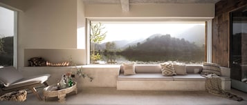 Uma área de estar aconchegante com vista para um lago e montanhas.