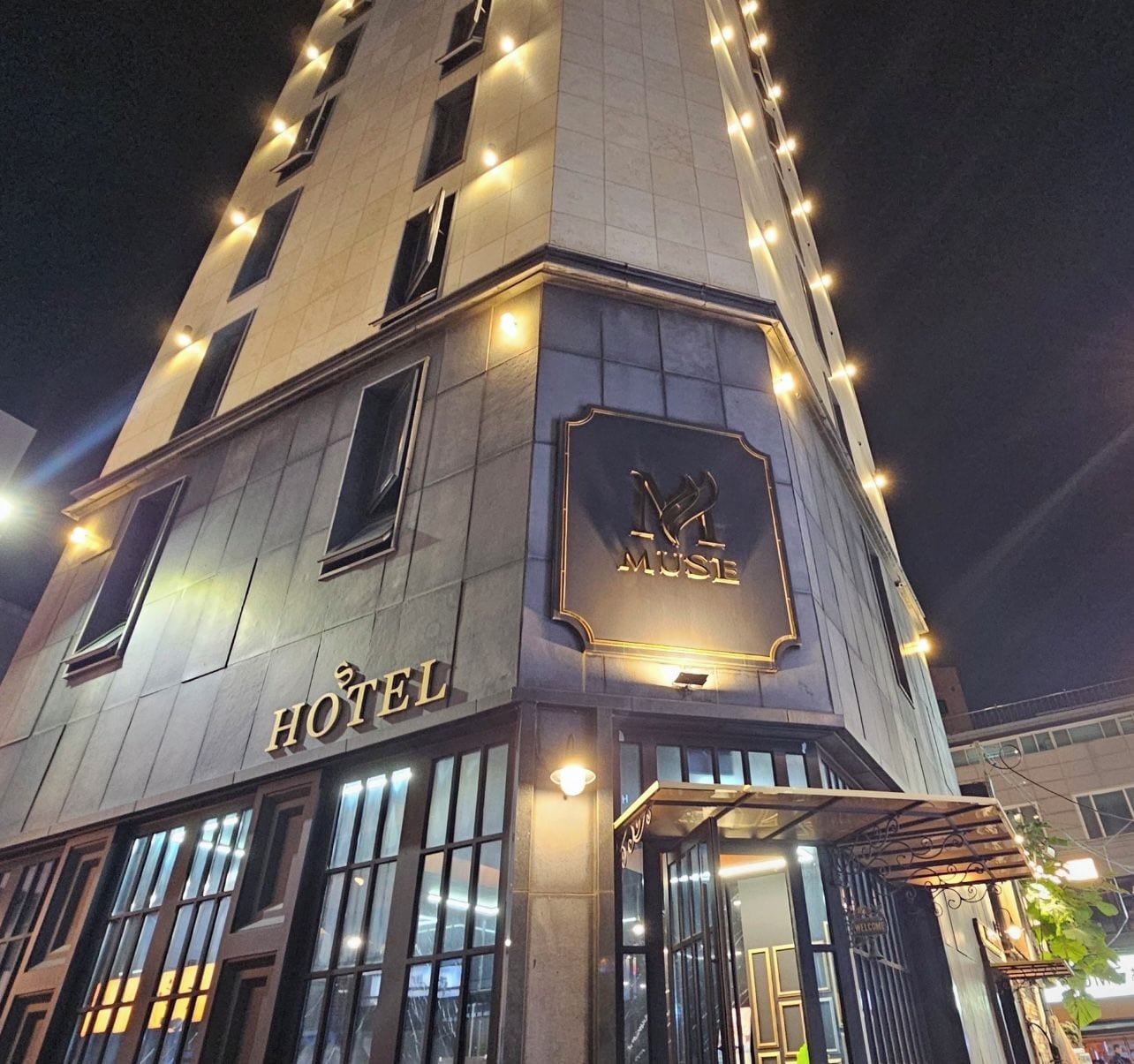 Un hotel con fachada moderna, señalización iluminada y una entrada acogedora.