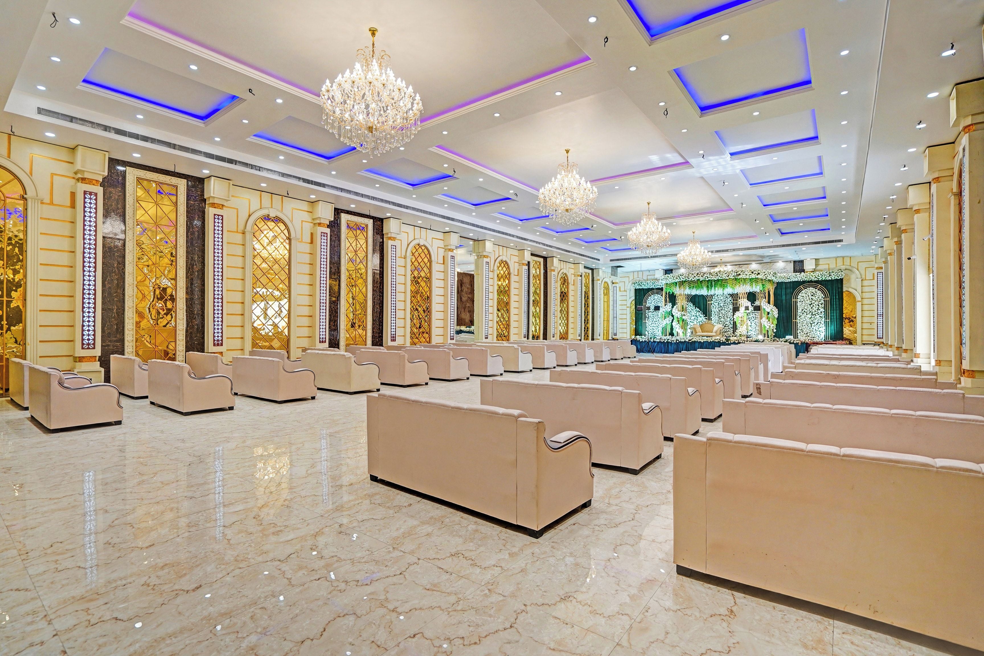 Un amplio salón con filas de asientos, decoraciones ornamentales en las paredes y candelabros.