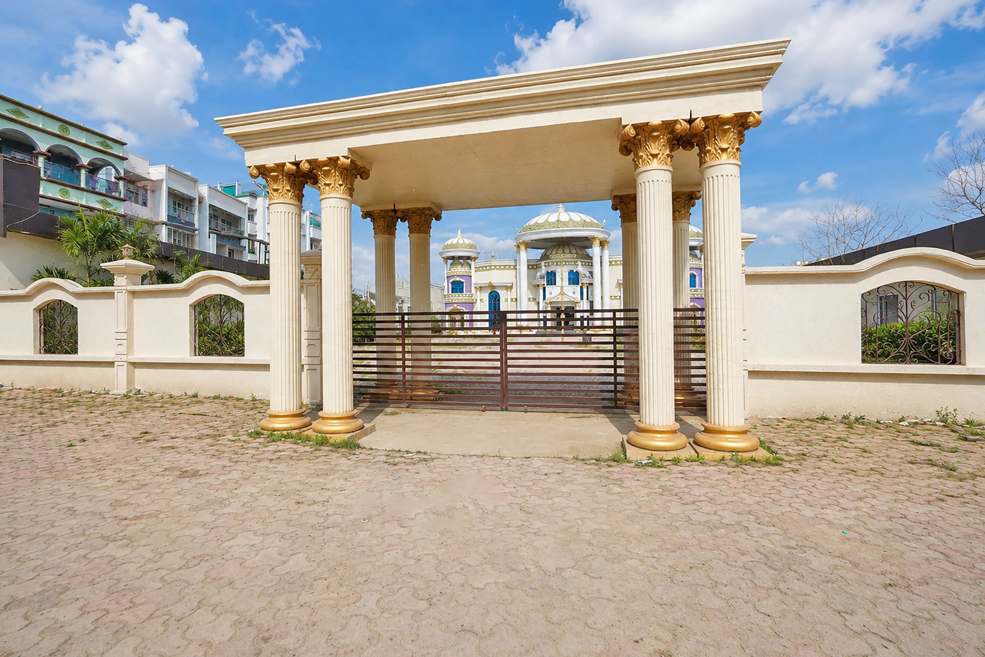 A covered entrance with classical columns and a gated entrance.
