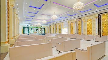 A spacious hall with rows of seating and ornate wall decorations.