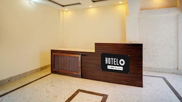 A hotel reception desk with a sign indicating it is serviced by OYO.