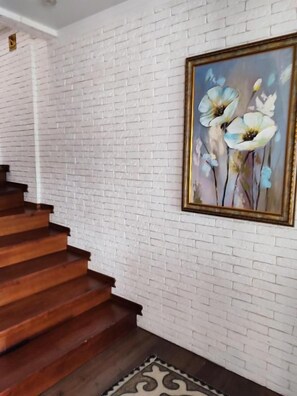 A staircase with wooden steps leading to a white brick wall.