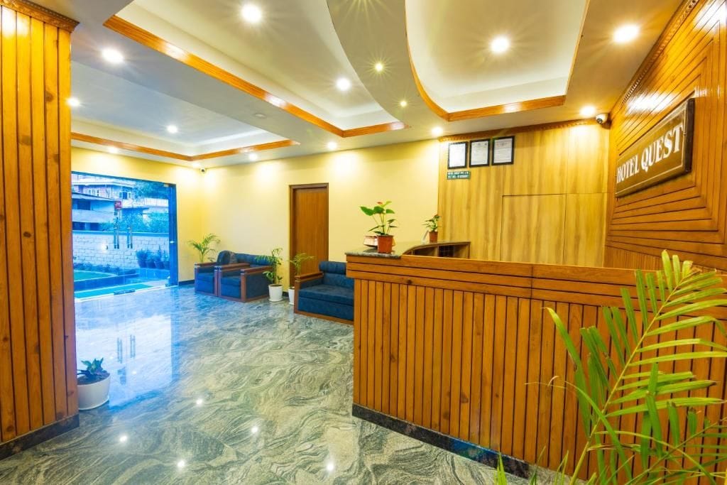 Un vestíbulo de hotel con mostrador de recepción, zona de estar y vistas a la piscina.