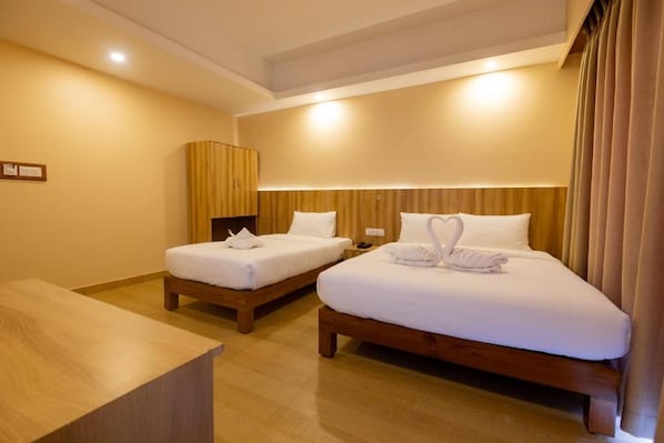 A hotel room with two beds, a wooden headboard, a bedside table, and a large window with curtains. - Hotel Quest (Pokhara)