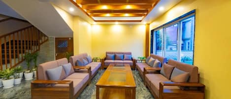 Un vestíbulo con techo de madera, una mesa de centro y sofás distribuidos a su alrededor.