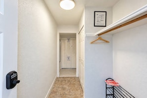 Ein Flur mit einer Tür, einem Kleiderständer und einem gerahmten Zertifikat an der Wand.