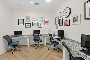 Una sala de conferències amb una taula llarga, tres cadires i un rellotge a la paret.