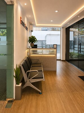 A modern reception area with a waiting bench, a potted plant, and a reception desk. - Modern apartment in Gazcue, near the Zona Colonial - Malecón (Santo Domingo)