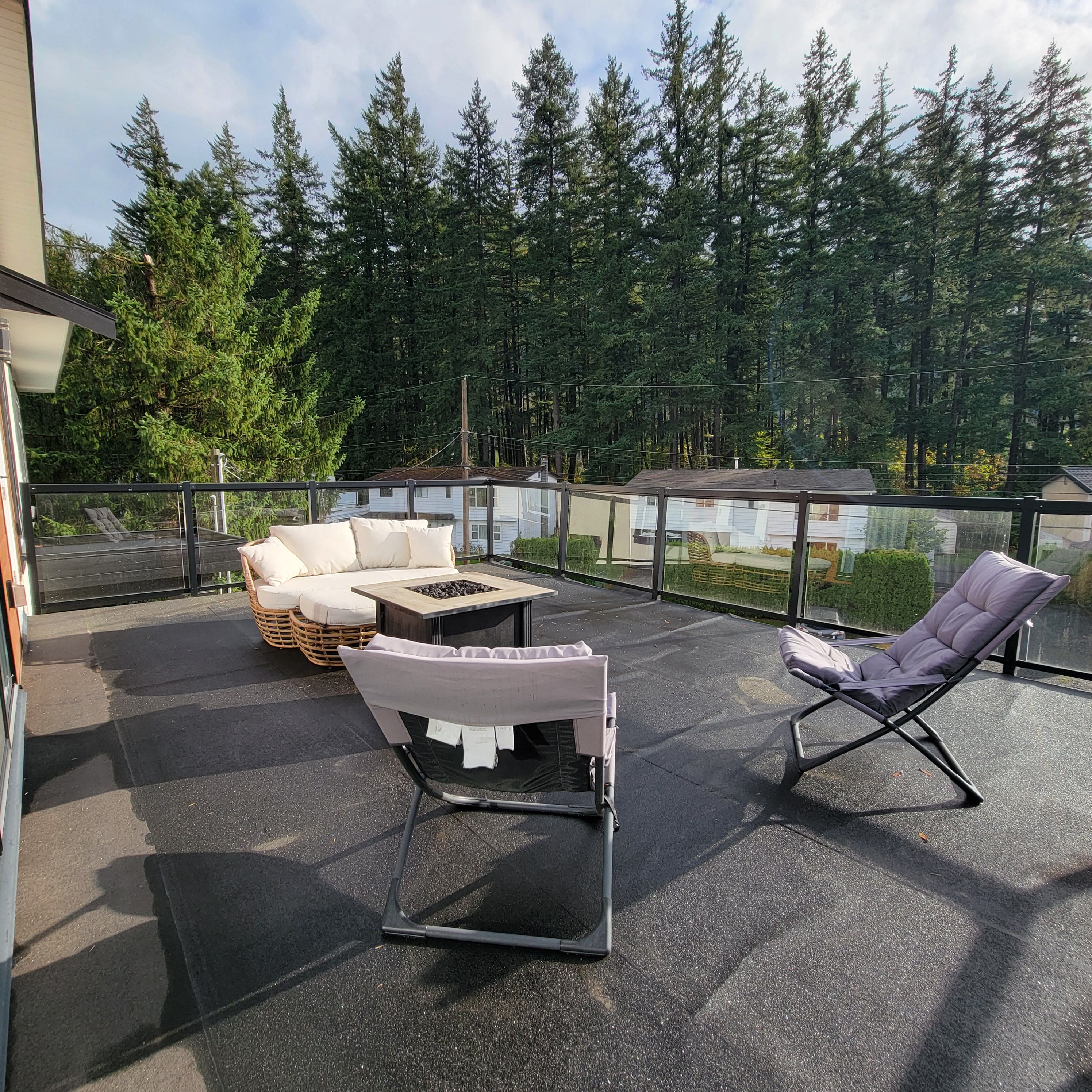 Una terrazza esterna con un divano, una poltrona imbottita e un tavolino.