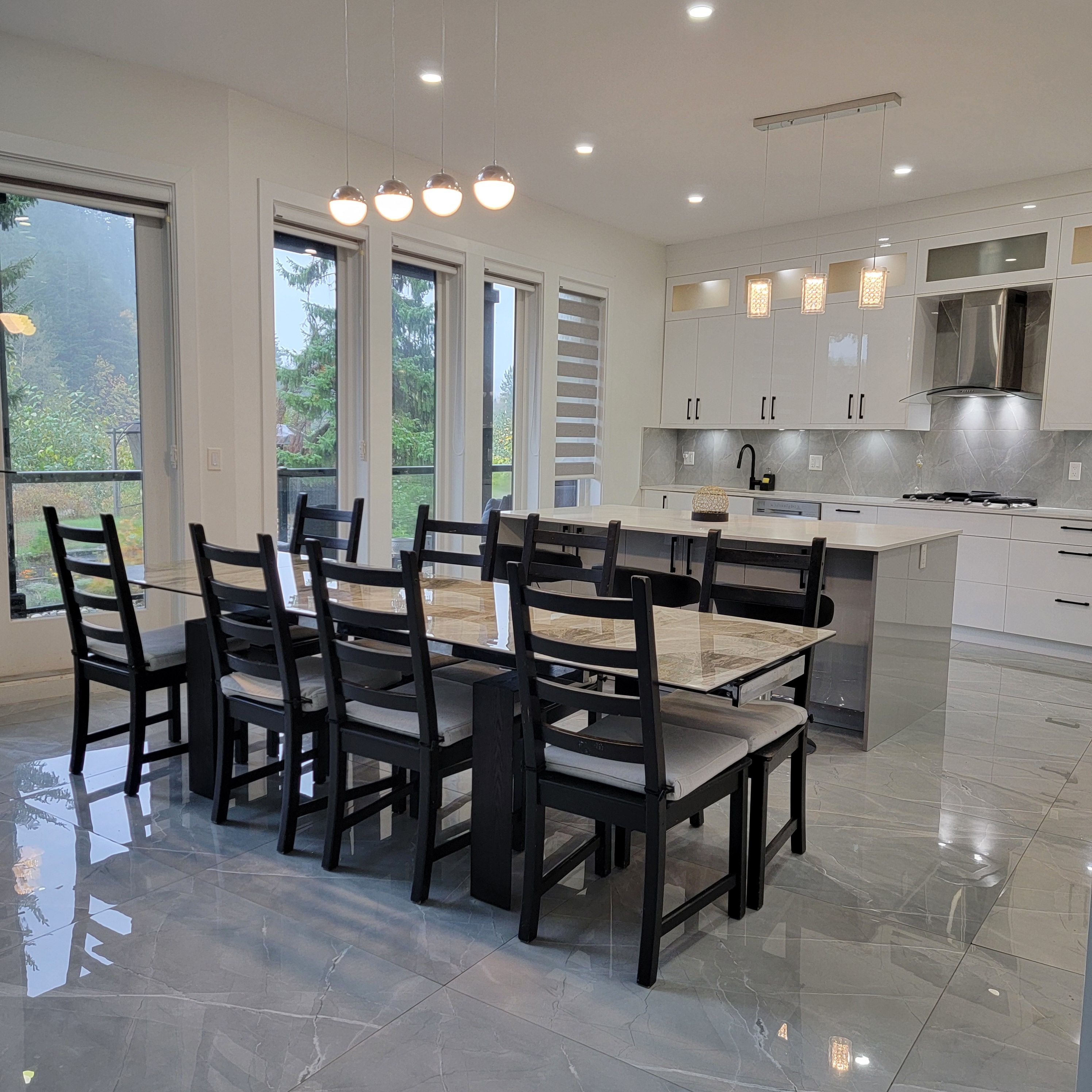 A modern kitchen with white cabinets, a central island, and pendant lighting.