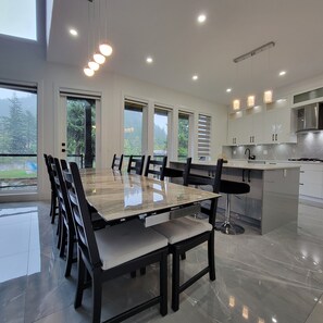 A modern kitchen with a large island, stainless steel appliances, and ample counter space. - Nature's Lodge on the River (Hope)