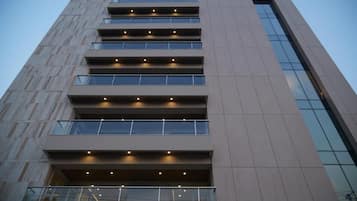 Un immeuble à plusieurs étages doté d’une architecture moderne, caractérisé par une série de balcons et de grandes fenêtres.
