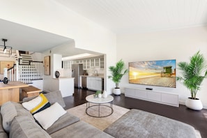 A modern living room with a sofa, coffee table, and a TV mounted on the wall. - Fantastic 2-bedroom condo in soothing Palm Beach Gardens (Palm Beach Gardens)