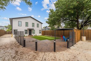 A residential backyard with a house, a fenced play area, and a tree. - Chic 1 BR Art Deco-Bishop Arts-Nr Downtown Dallas (Dallas)