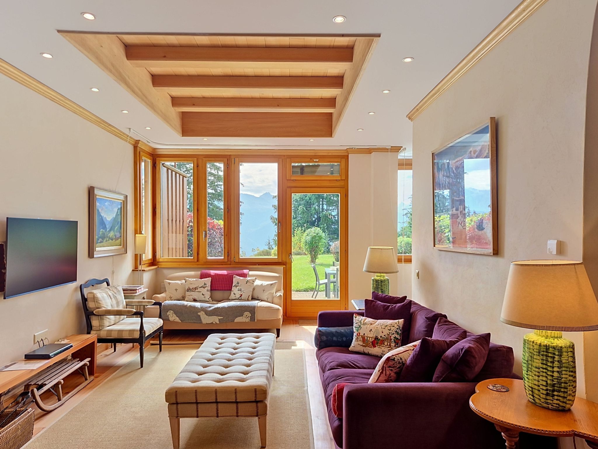 A spacious living room with a high ceiling, large windows, and a view of the outdoors.