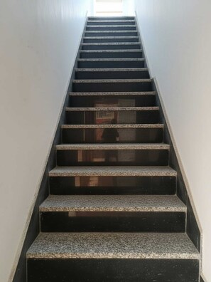 A staircase with a handrail, leading upwards.