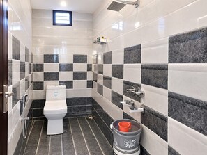 A bathroom with a toilet, a shower, and a sink. - Hotel New Supreme (Ajmer)