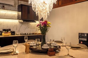 A dining table set with plates, glasses, and a vase with flowers. - Eco Club House (Bali)