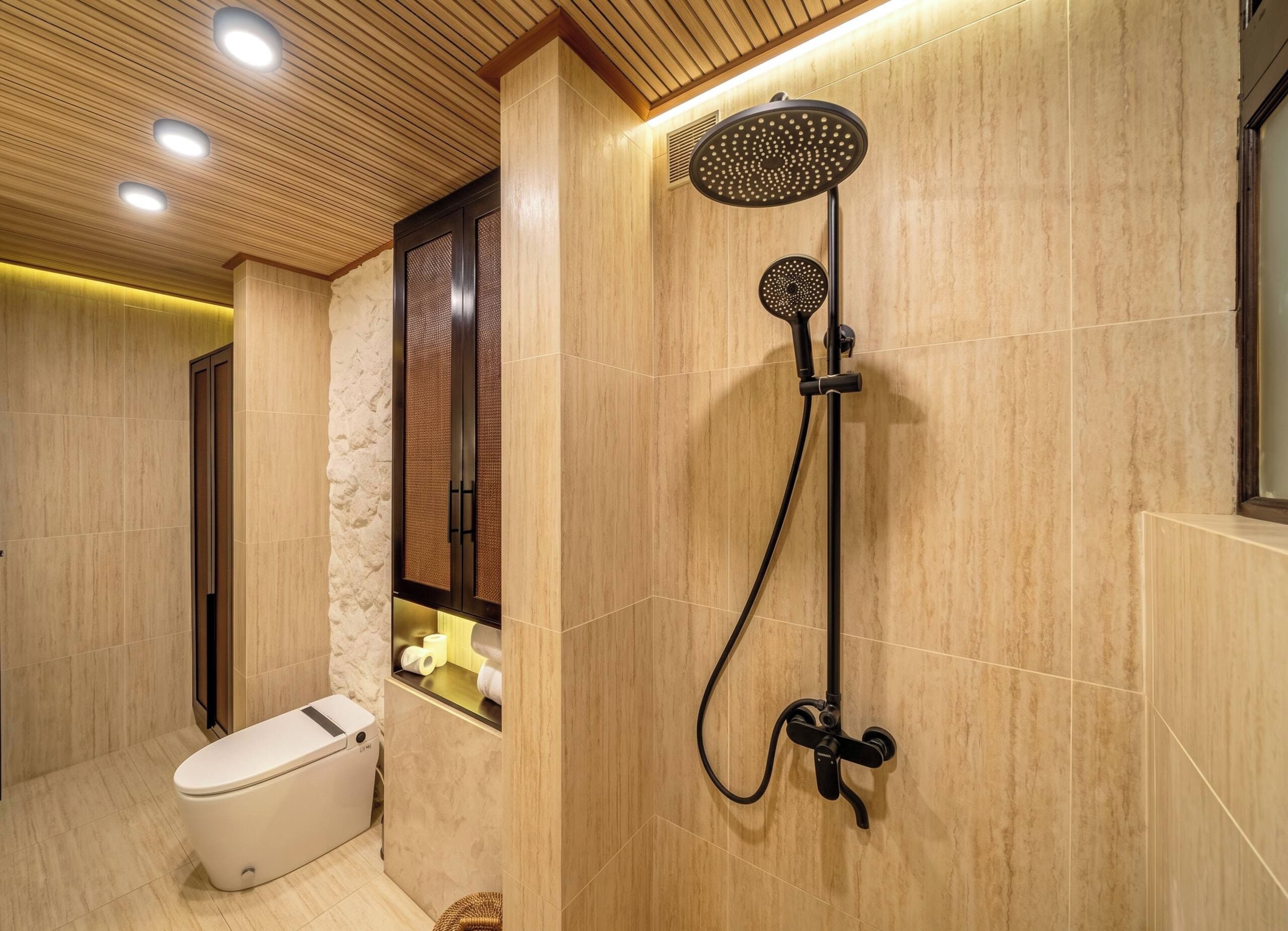 Un baño moderno con ducha, inodoro y techo de madera.