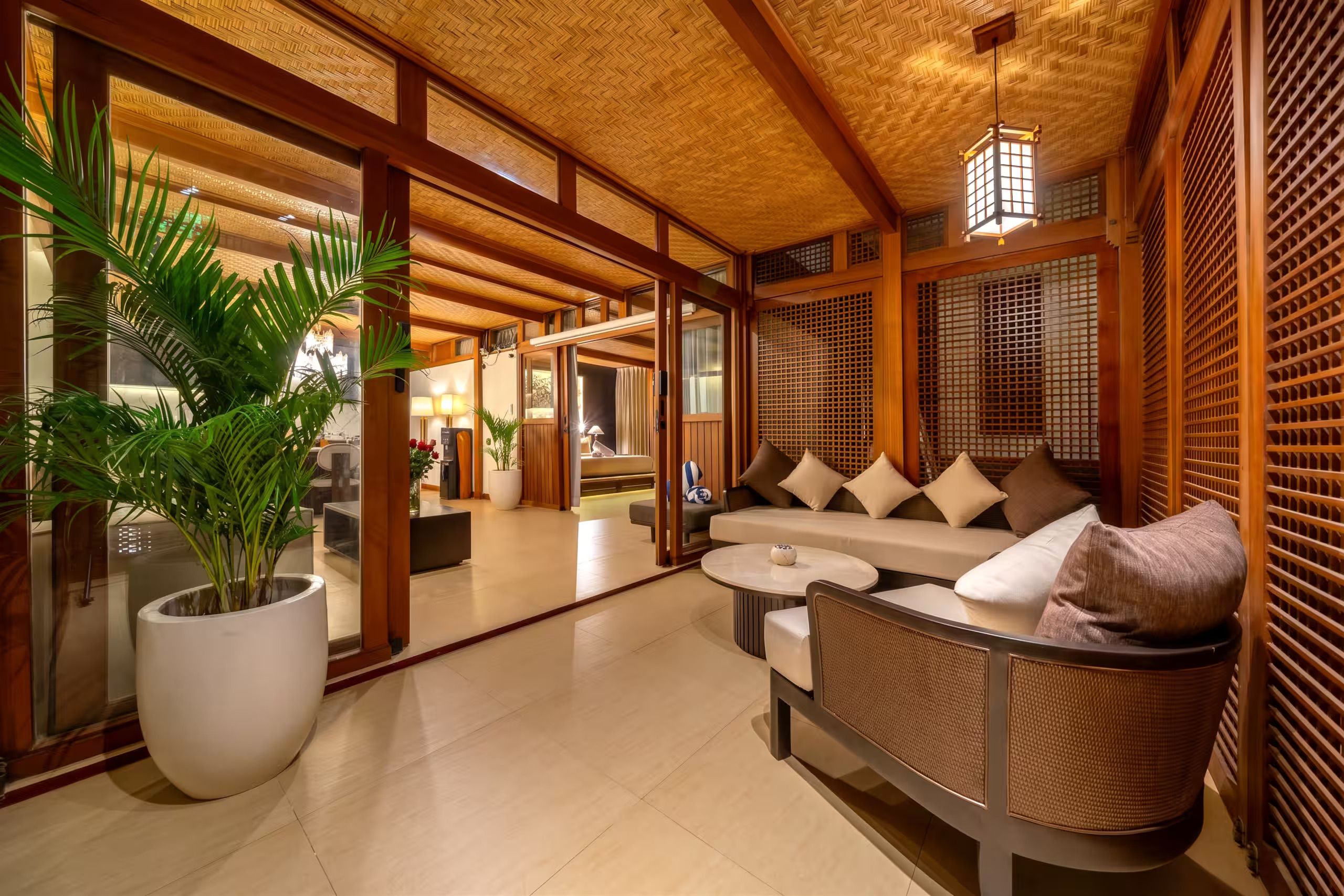A modern interior with a sofa, a round table, and a large potted plant.