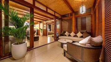 A modern interior with a sofa, a round table, and a large potted plant.