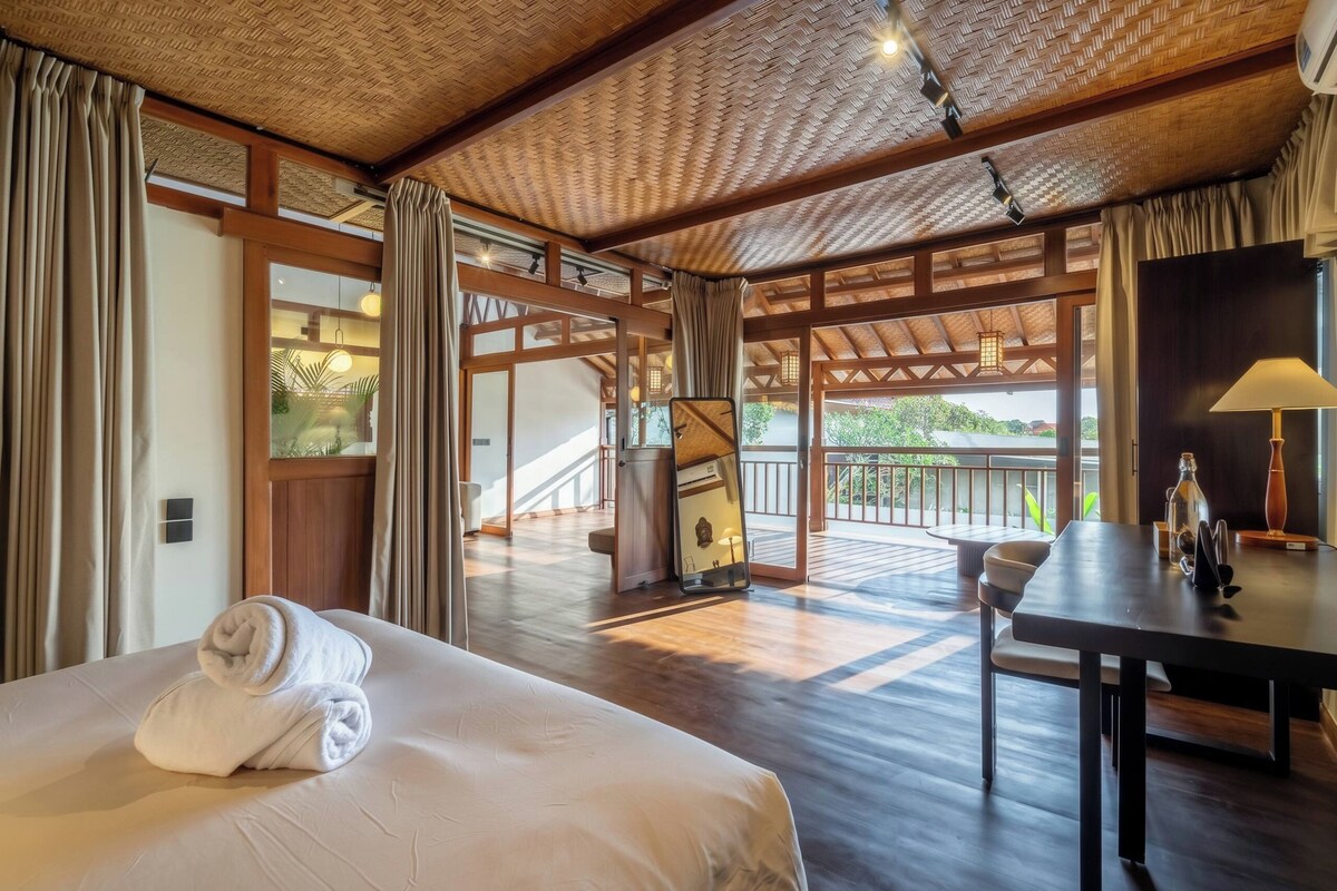 Een hotelkamer met een groot bed, een eettafel en uitzicht op de omgeving.