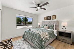 A bedroom with a bed, a nightstand, a lamp, a ceiling fan, and a window with a view of the outside. - Welcome to your private retreat situated on over an acre lot with pool/spa (Visalia)