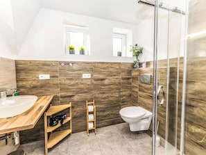 A modern bathroom with a wooden vanity, a toilet, and a shower area. - Klarka 4 by Interhome (Rokytnice nad Jizerou)
