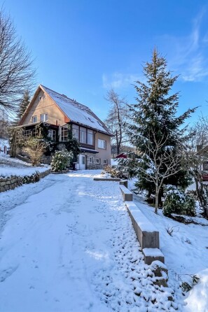 A house with a sloped roof, a stone pathway leading to the entrance, and snow-covered ground. - Klarka 3 by Interhome (Rokytnice nad Jizerou)