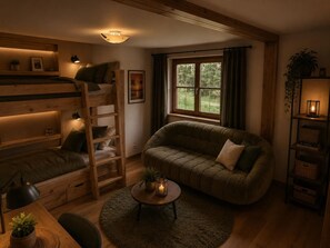 A cozy room with a bunk bed, a sofa, a small table with candles, and a window with curtains. - Enjoy mountain panorama with luxury & ambiance (Krimml)