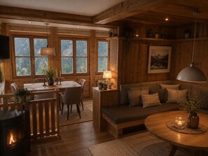 A cozy cabin interior with a dining area, sofa, and a fireplace. - Enjoy mountain panorama with luxury & ambiance (Krimml)