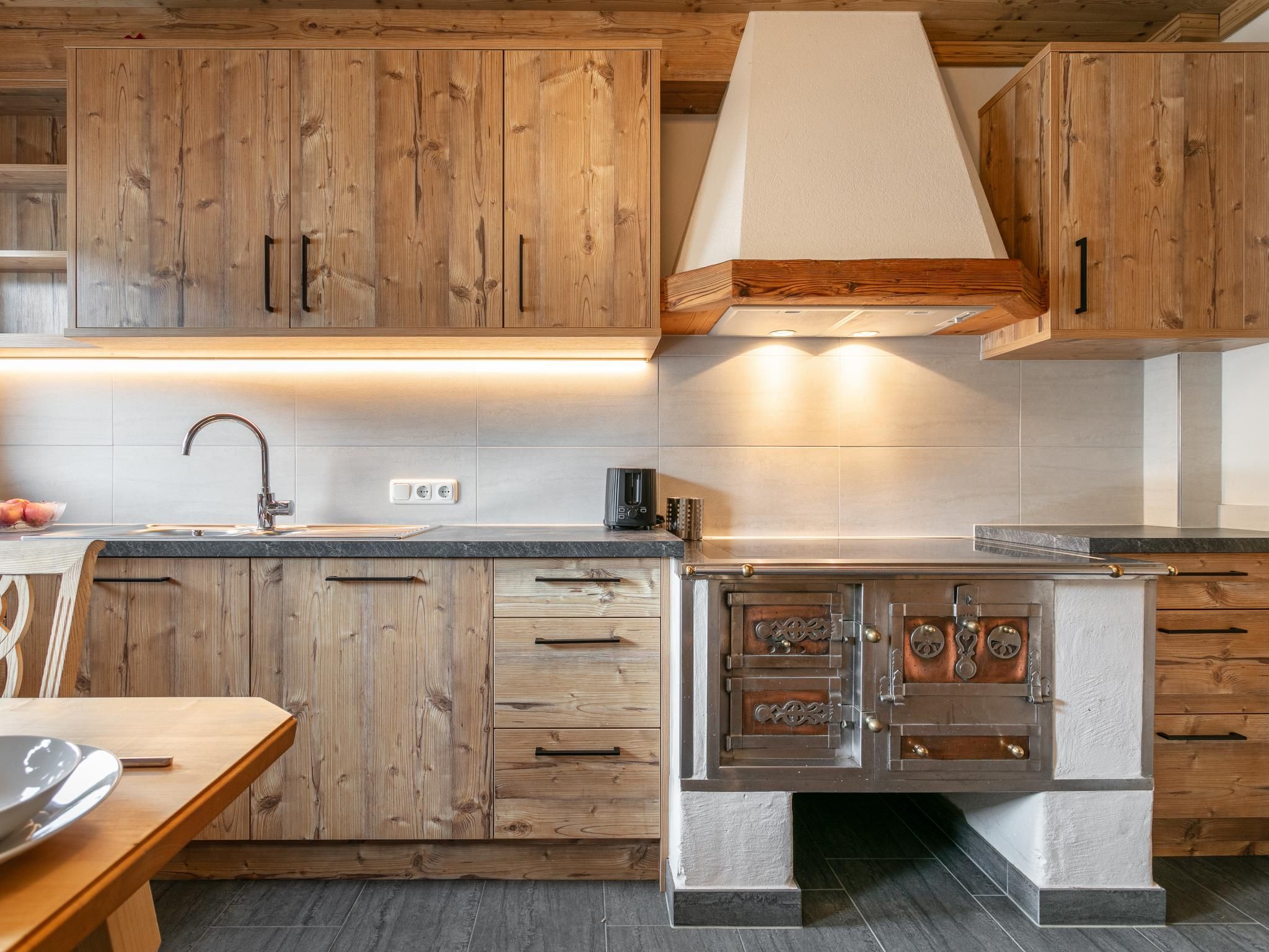 Una cucina con mobili in legno, un lavandino in acciaio inossidabile e un forno integrato.