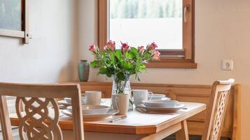 Ett matbord med en vas med blommor, vita tallrikar och koppar.