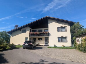 Uma casa de dois andares com um carro estacionado na entrada.