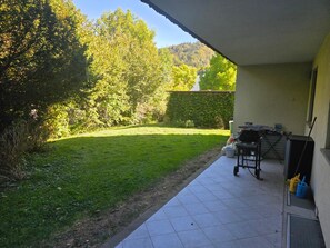 A patio area with a tiled floor, a small table, and a chair. - Cozy apartment with a view of Lake Constance (Hörbranz)