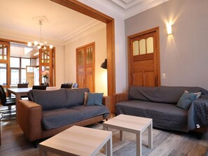 Una sala de estar con un sofá, dos mesas de centro y un comedor con sillas y una mesa.
