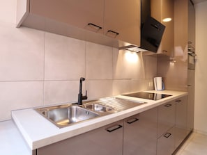 A modern kitchen with stainless steel appliances, a double sink, and integrated lighting. - Group house in a typical style in Dinant (Dinant)