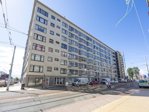 A multi-story building with a flat facade, large windows, and a ground-level entrance. - Bright studio on the 7th floor (Middelkerke)