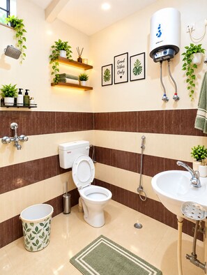 Een moderne badkamer met toilet, wastafel, douche en een boiler.
