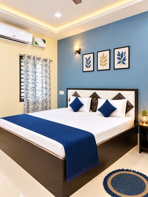 Een hotelkamer met een bed, nachtkastje, een wandairconditioner en een raam met gordijnen.