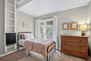 A bedroom with a bed, a dresser, a window with curtains, a framed picture on the wall, and a ceiling light. - Charming Spacious Retreat - 5 mins from The Woodlands Mall & i45 (Conroe)