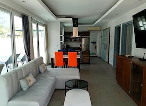 En moderne stue med sofa, sofabord og fjernsyn.