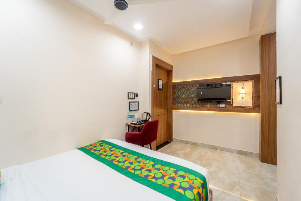 A hotel room with a bed, a desk, and a kitchenette area.