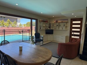 A living room with a pool, a dining table, and a TV. - House with own private pool, an easy walk to the Beach, Restaurants and Cafe's (Cronulla)