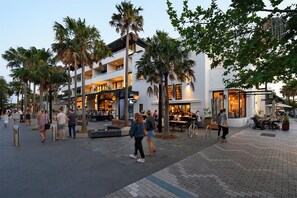 A multi-story building with outdoor seating areas and palm trees. - House with own private pool, an easy walk to the Beach, Restaurants and Cafe's (Cronulla)