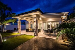 A modern house with a covered patio, outdoor seating, and a stone exterior. - Orchid Paradise Homes OPV314 (Hua Hin)