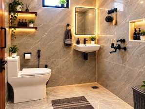 Un bagno moderno con toilette, lavandino e specchio. Sono presenti mensole con articoli da toilette e una pianta in vaso.