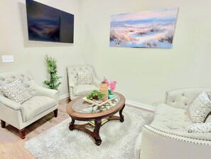 A living room with two armchairs, a coffee table, and a painting on the wall. - Newly Built 3-bedroom modern house with parking in vibrant Downtown San Antonio (San Antonio)
